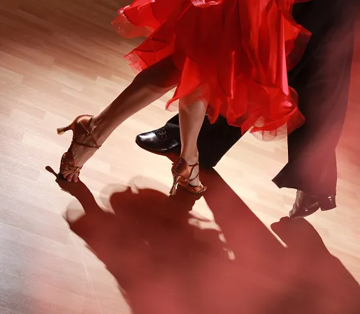 Couple en danse latine élégante sur une piste lumineuse et chaleureuse